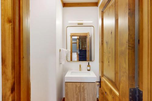 a bathroom with a sink and a mirror at Aspen Cabin in Victor