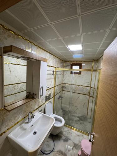 a bathroom with a sink and a toilet and a mirror at Fındıkoğlu Otel in Çaykara
