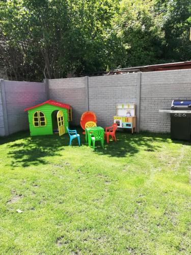 a yard with four colorful chairs and a dog house at Ubytování Pálava Perná in Perná