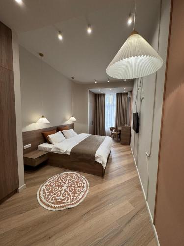 a bedroom with a large bed and a rug at Bugu Hotel Bishkek in Bishkek