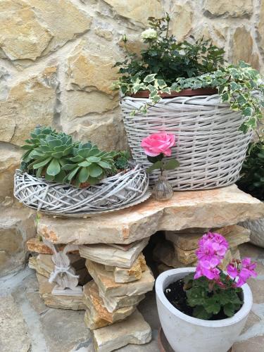 two baskets of flowers and plants on a stone wall at Casa di Lavanda in Hvar