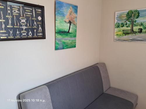 a couch in a room with three pictures on the wall at Top floor on villa, 3' from center, by the sea! Host is Efi Kwsta in Preveza