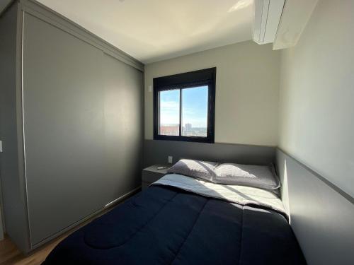 a small bedroom with a bed and a window at Apartamento Aconchegante e Completo no Coração da Cidade in Dourados