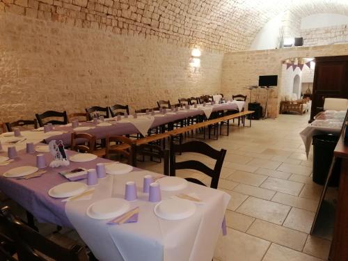 a large room with tables and chairs with purple napkins at B&B Masseria Spilafemine in Turi