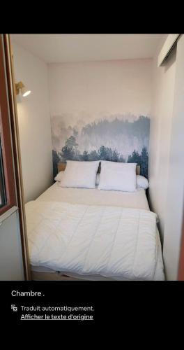 une chambre avec un lit avec un tableau sur le mur dans l'établissement Appartement à la Montagne à 1650 m, à Saint-François-Longchamp