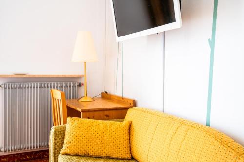 a living room with a yellow couch and a table at Enrosadira in Predaia