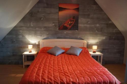 - une chambre avec un grand lit orange et 2 oreillers dans l'établissement Ti Penn Gite de Saint Guénolé, à Trévou-Tréguignec