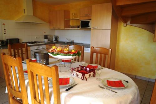 une cuisine avec une table et des chaises blanches dans l'établissement Ti Penn Gite de Saint Guénolé, à Trévou-Tréguignec
