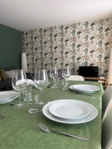 une table avec des assiettes et des verres à vin dessus dans l'établissement Le Vieux Fenil, à Yvoire