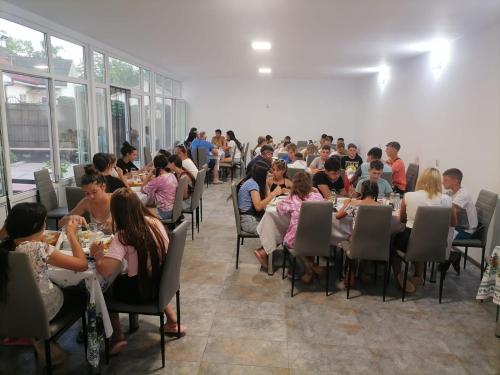 a group of people sitting at tables in a room at Sea Breeze Costinești in Costinesti