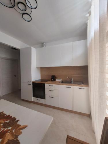 a kitchen with white cabinets and a sink at SUNSHINE- 2 minutes walk to Bernina Express in Tirano