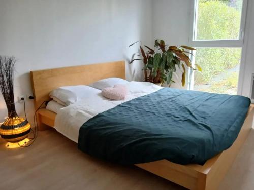 - un lit dans une chambre avec une plante dans l'établissement Appartement cosy à Caen avec terrasse et jardin, à Caen