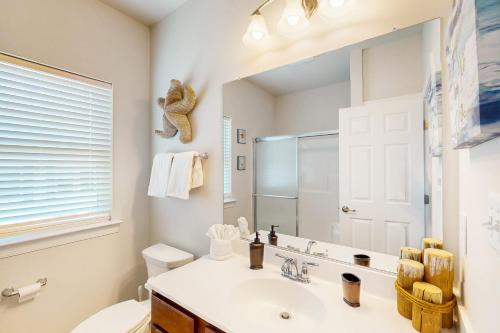 a bathroom with a sink and a mirror at Bay Dreams --- 31415 Erie Ave in Ocean View