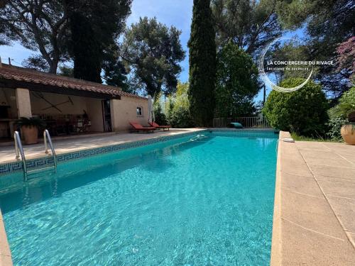 une grande piscine bleue devant une maison dans l'établissement La Ratopenado - Villa Provençale - Piscine, à Carqueiranne
