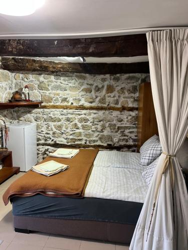 a bedroom with a bed with a brick wall at Cottage Modrich in Struga