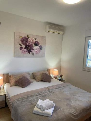 a bed in a bedroom with a picture on the wall at Apartment Viniška in Vinišće