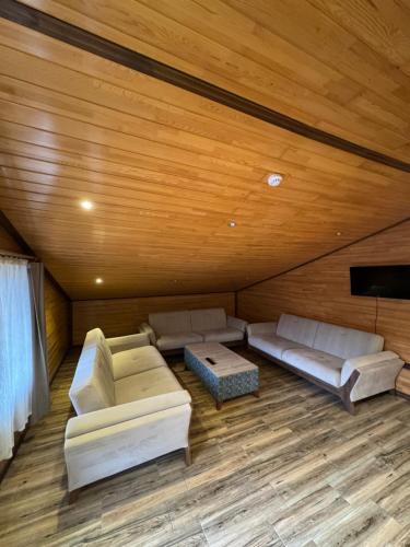 a living room with two couches and a tv at Fındıkoğlu Otel in Çaykara