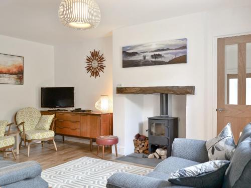 a living room with a couch and a fireplace at 3 Barf Cottages in Portinscale
