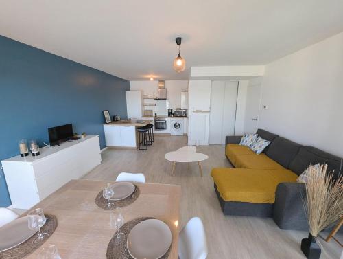 un salon avec un canapé et une table dans l'établissement Séjour tout à pied, idéal famille, parking privé - Linge et ménage inclus, au Pouliguen