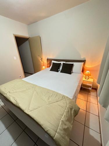 a bedroom with a large bed with white sheets and pillows at J Lindo Sobrado 2 quartos em condomínio no Centro in Marília