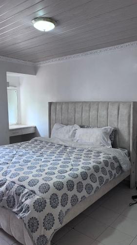 a bedroom with a bed with a blue and white comforter at Tina Villa in Nairobi