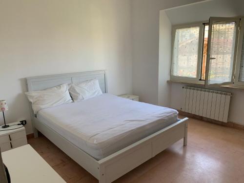 ein Schlafzimmer mit einem weißen Bett und zwei Fenstern in der Unterkunft Marechiaro in Anzio