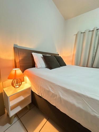 a bedroom with a bed and a lamp on a night stand at J Lindo Sobrado 2 quartos em condomínio no Centro in Marília