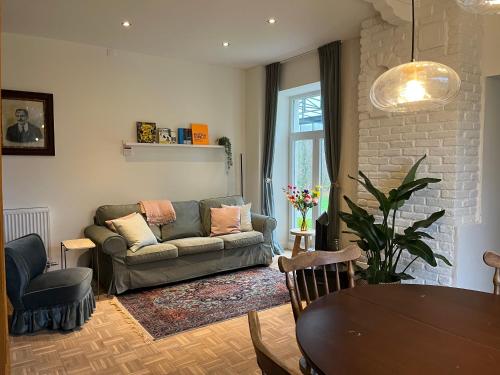 a living room with a couch and a table at Vakantiewoning de Toren in Kortessem
