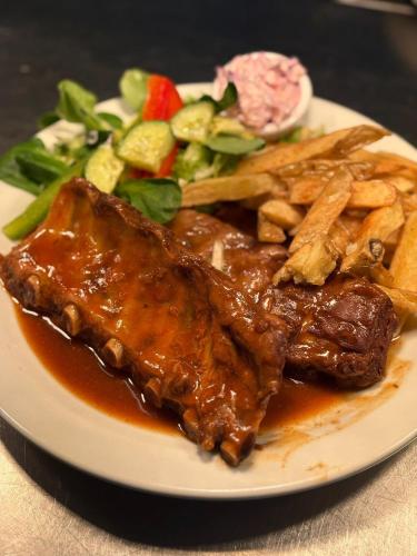 a plate of food with meat and a salad at The Greyhound Inn in Grizebeck