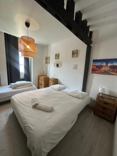 une chambre avec un grand lit blanc et une fenêtre dans l'établissement Maison bohème centre ville avec parking, à Orléans