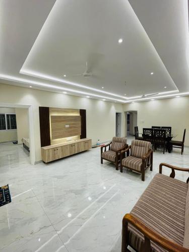 a large lobby with chairs and a large screen at Visitors Lounge by MMG - 2&3BHK Furnished - Rd 12 Banjara Hills in Hyderabad