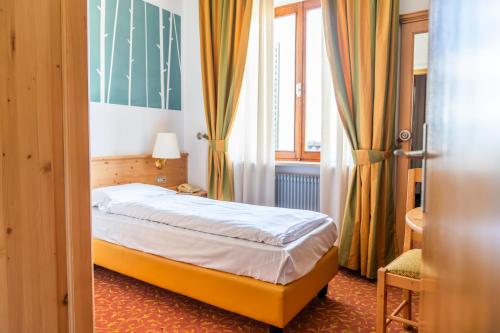 a small bedroom with a bed and a window at Enrosadira in Predaia