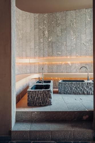 a bathroom with two sinks and a fountain at Jungbrunn Der Gutzeitort in Tannheim