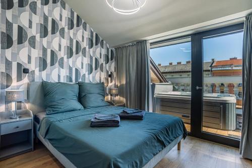 a bedroom with a bed with a view of a balcony at Exclusive 2-Bedroom Penthouse with Jacuzzi in Budapest