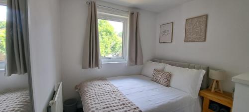 a small bed in a room with a window at Charming 3 bed near A1 and central Peterborough in Peterborough