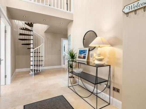 a hallway with a staircase and a table with a lamp at Whispering Meadows in Renvyle