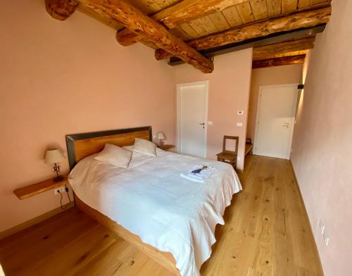 a bedroom with a large bed with wooden floors at Villard Guesthouse in Oulx