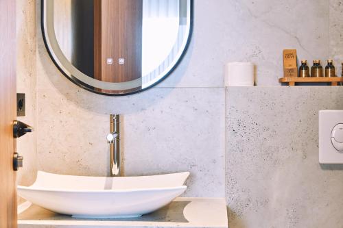 a bathroom with a bowl sink and a mirror at Ruby Hotel Prishtina in Pristina