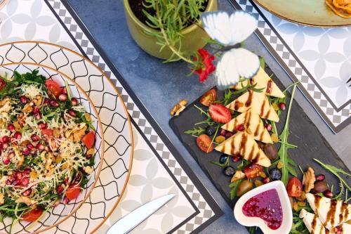 a table with two plates of food and a salad at Ruby Hotel Prishtina in Pristina