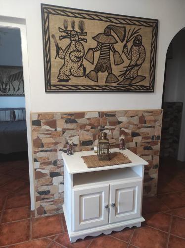 a small white table in a room with a stone wall at El Cortijo Escondido Ohanes in Ohanes