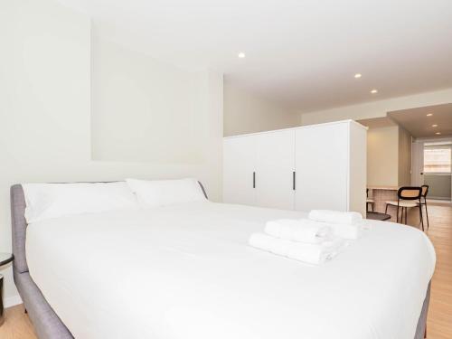 a white bedroom with a white bed and a dining room at YBH Atlantic Boutique in Vigo