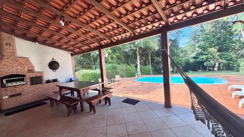un patio avec un hamac et une piscine dans l'établissement Sítio Topo do Mundo - Pólo Turístico INHOTIM na Serra da Moeda, à Brumadinho