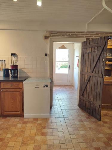 une cuisine avec une porte menant à une cuisine avec un comptoir dans l'établissement La Lavande - Perigord Vert,Dordogne, à La Roche-Chalais