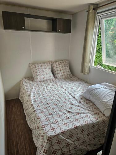 un lit dans une petite pièce avec une fenêtre dans l'établissement Mobil home, à Puget-sur Argens