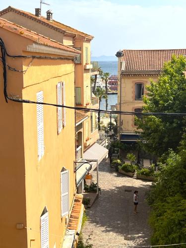 a person standing in an alley between two buildings at Hotel L'Escapade in Le Lavandou
