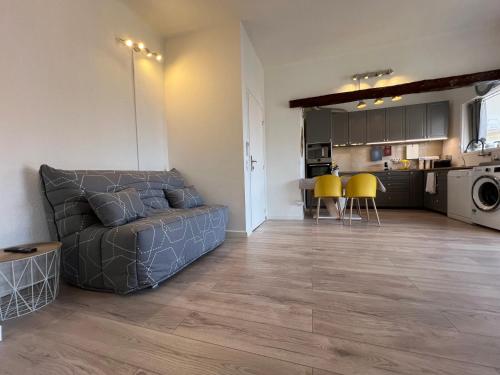 a living room with a couch and a kitchen at Hotel L'Escapade in Le Lavandou