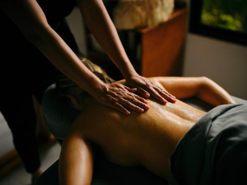 a woman getting a back massage from a therapist at Paradise Hot Springs - Thermal Water & Volcano Views in Fortuna