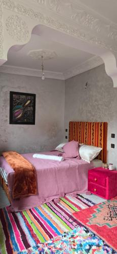 a bedroom with a large bed and a rug at Dar Nourdine in Imlil