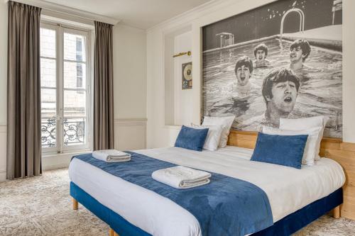 a bedroom with a bed with a large painting on the wall at Hôtel François 1er in La Rochelle