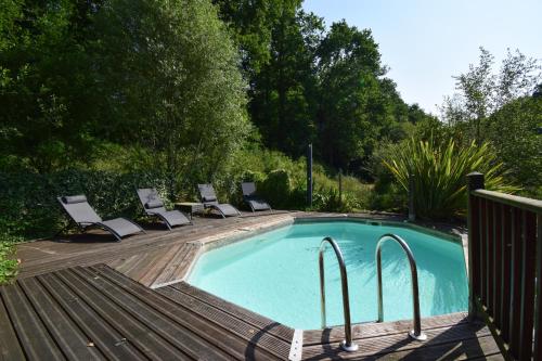 - une piscine avec des chaises longues à côté d'une terrasse en bois dans l'établissement Chalet avec piscine privée et lac à Sos, à Sos